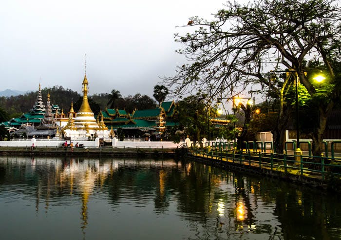 a temple complex reflecting in the water in mea hong song, thailand 