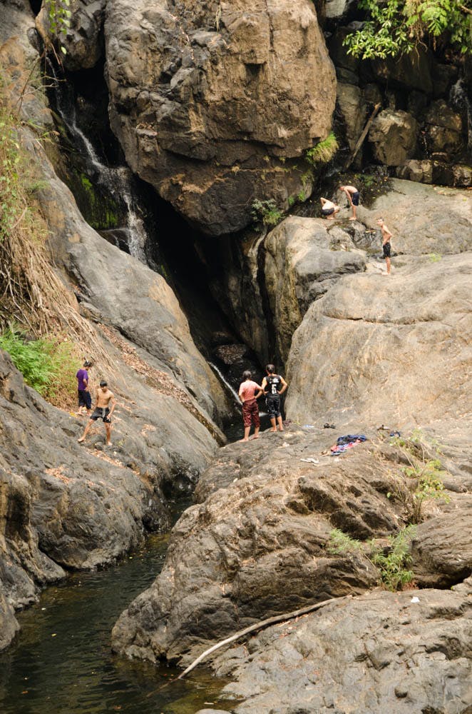 people standing near a waterfall in mea hong song, thailand 