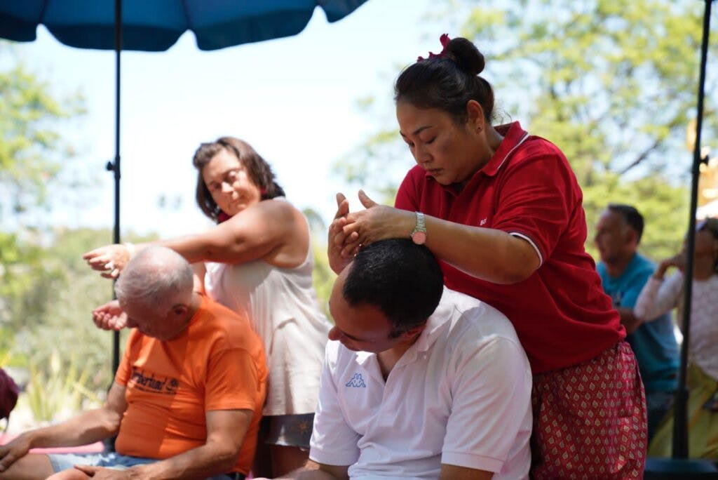 Two ladies massaging two men at the thai festival in lisbon. 