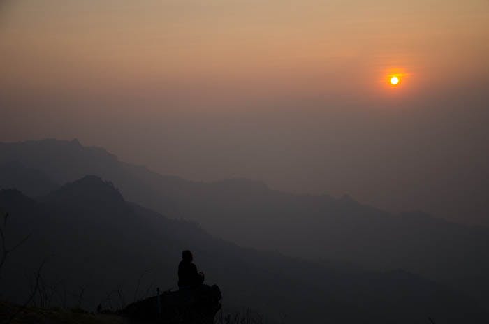 shadow of a woman sitting on the phu chi fa mountain at sunrise 