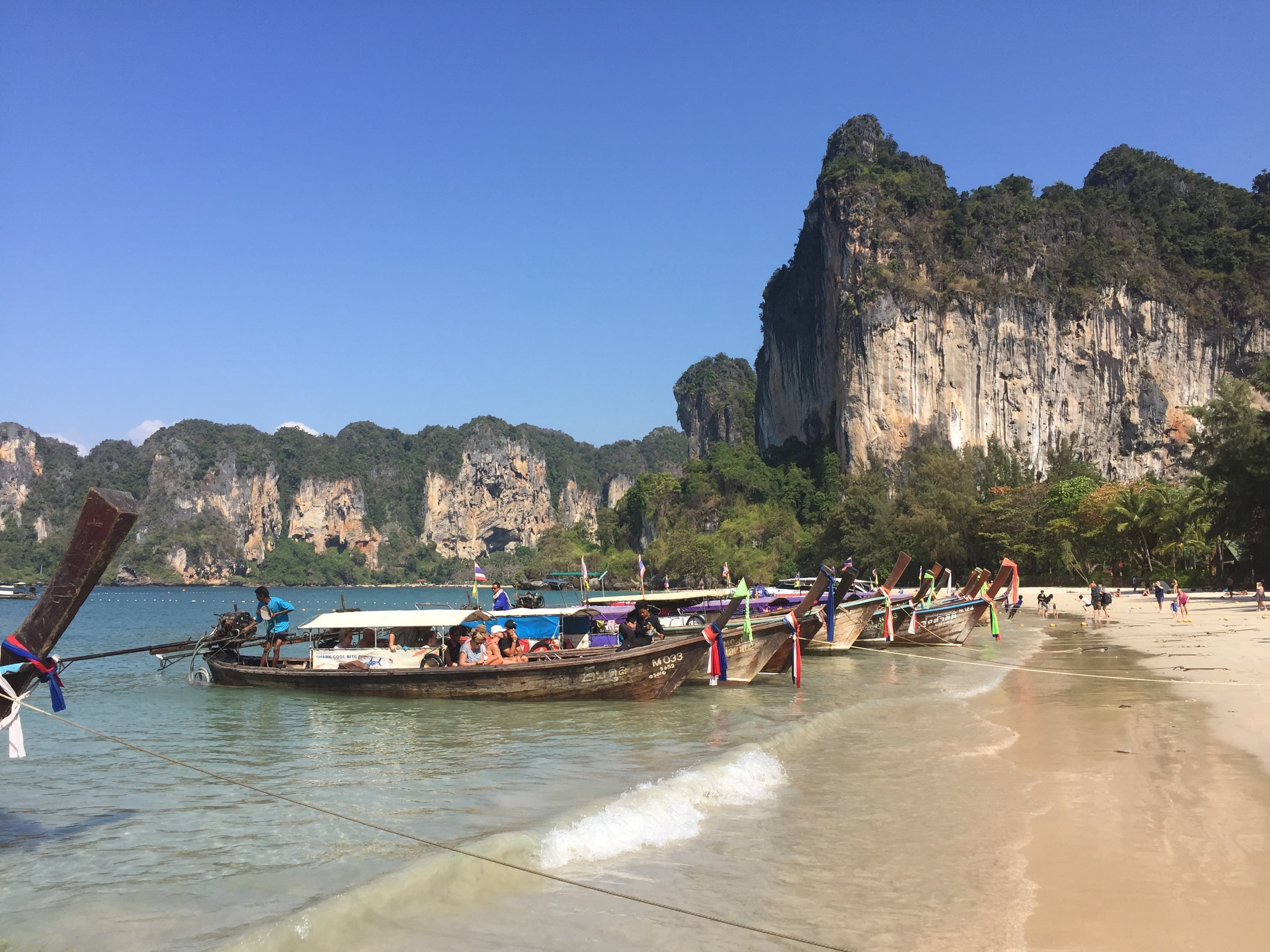 Travel healthy - colourful boats on a beach in thailand 