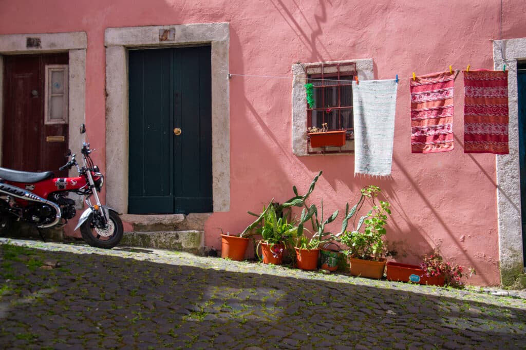 Street of Alfama, pink house with a motorbike