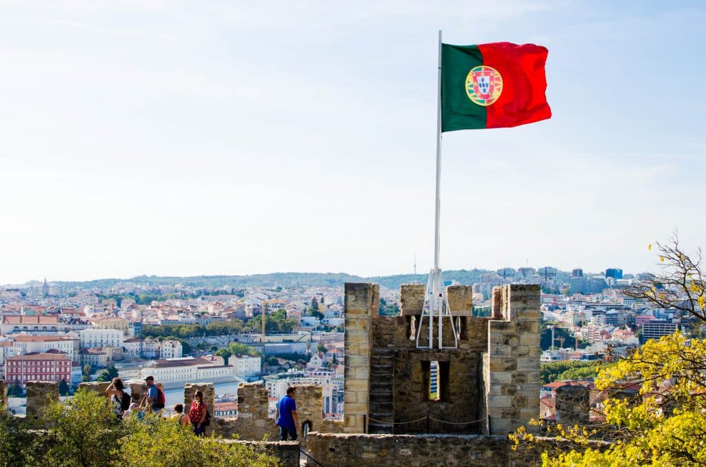 Portugalska flaga powiewa na zamku świętego jerzego w lizbonie. 