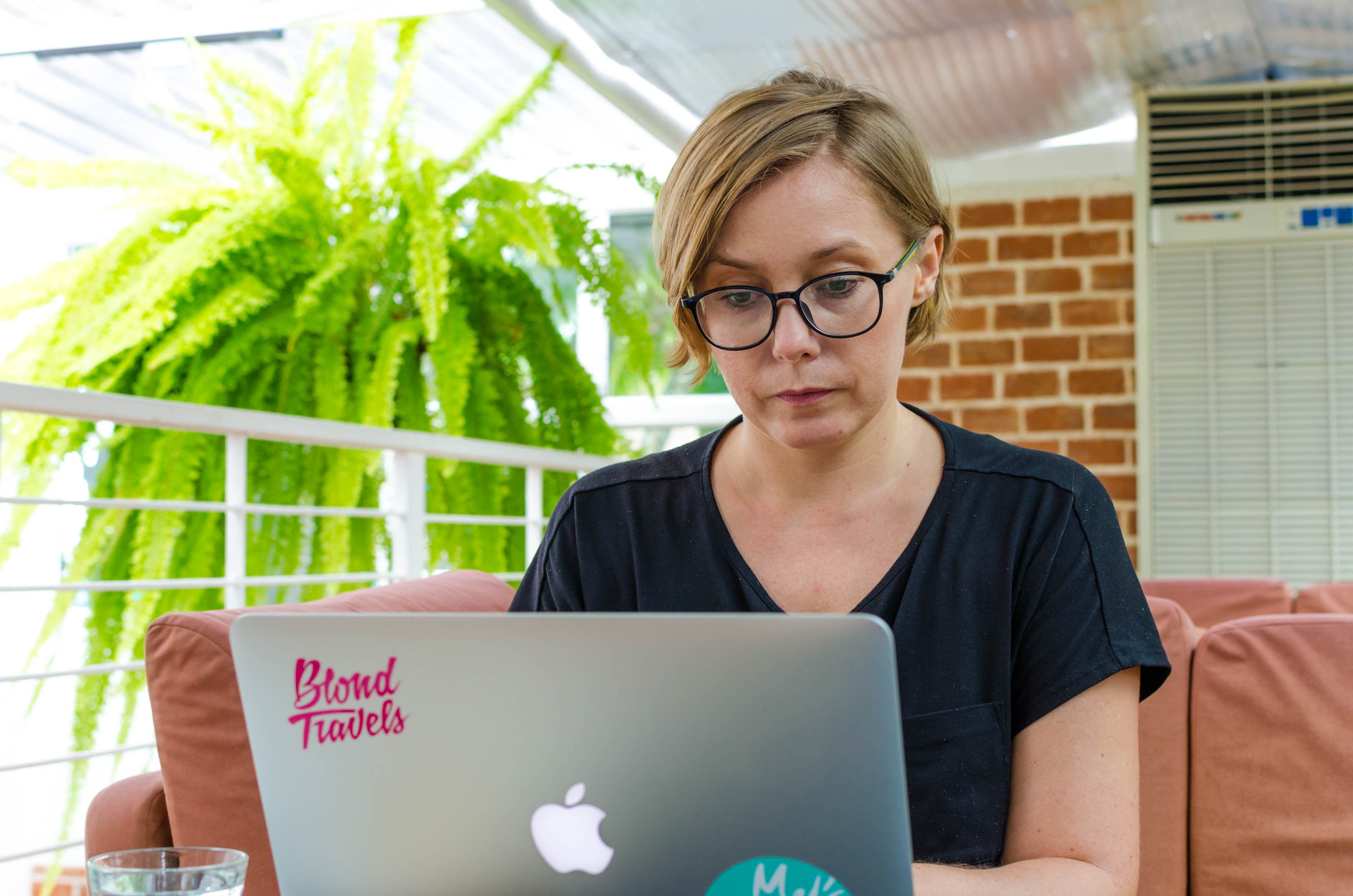 joanna horanin sits at a laptop in a green coffee shop