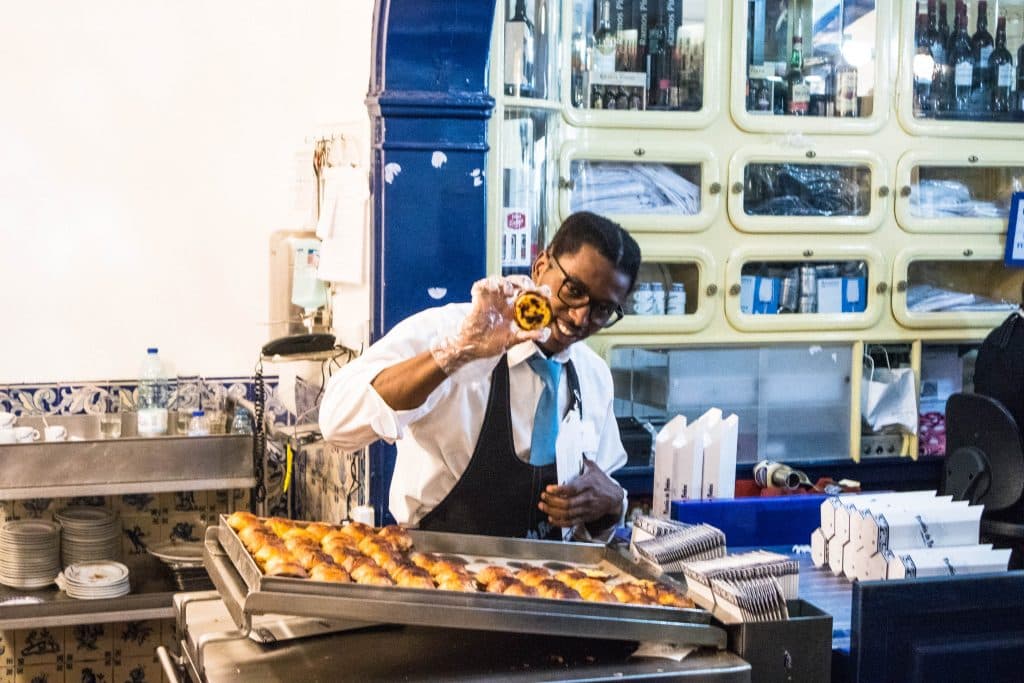 obsługa w pasteis de belem pokazuje pastel do nata