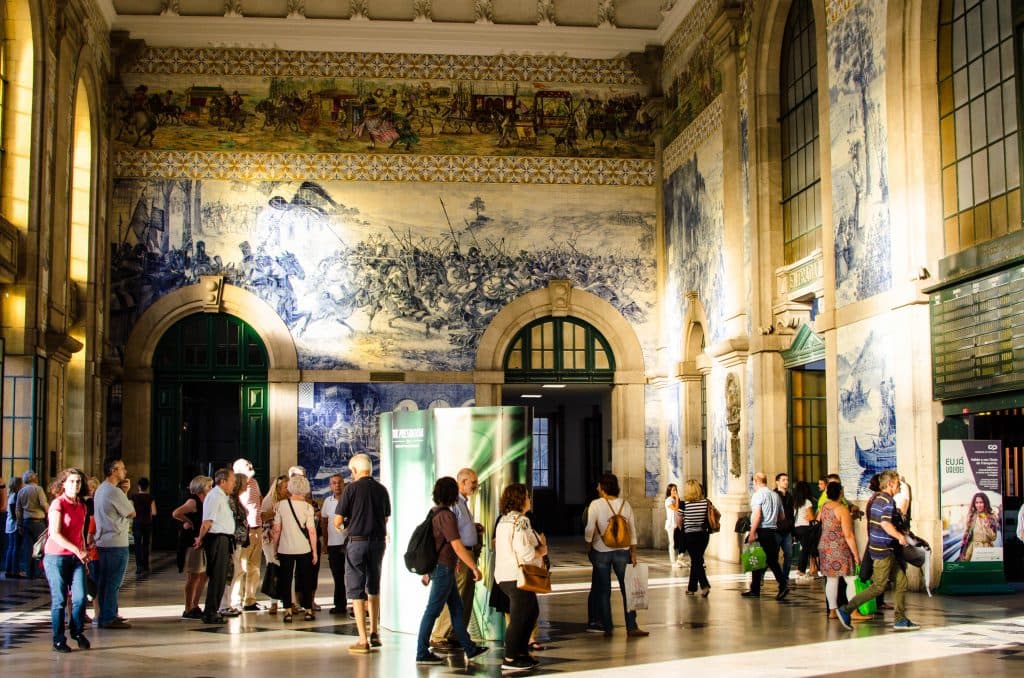 people walking in sao bento station admiring the azulejos 