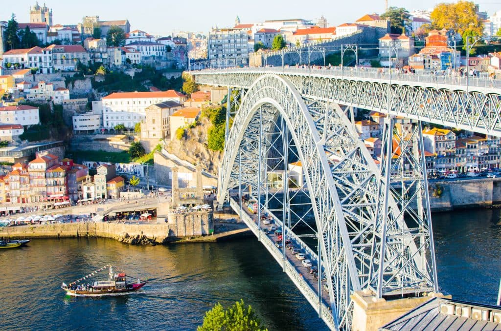 the view from dom louis bridge in porto. view of the city and a boat sailing underneath. 