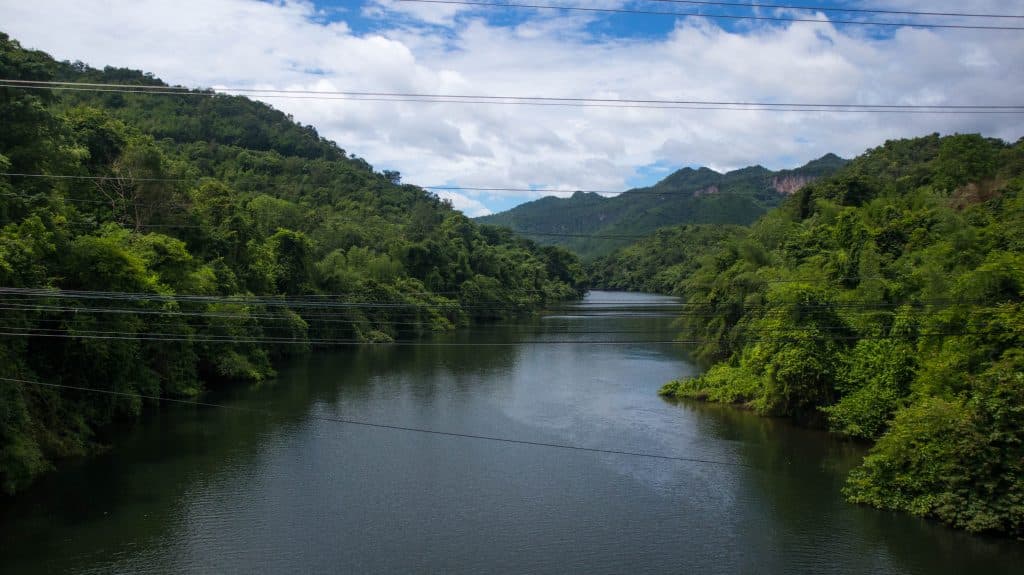 the views on the way to erawan waterfalls green hills and a river 