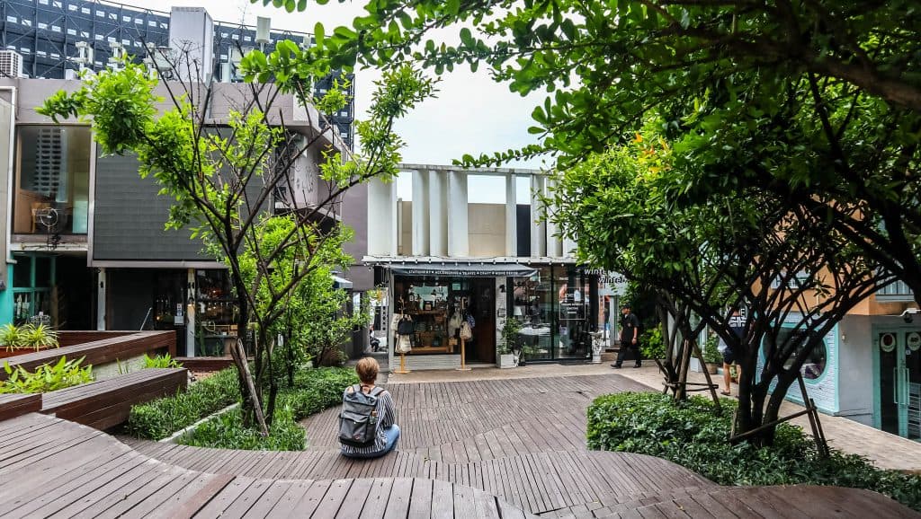 a woman sitting along on wooden stairs in chiang mai, thailand