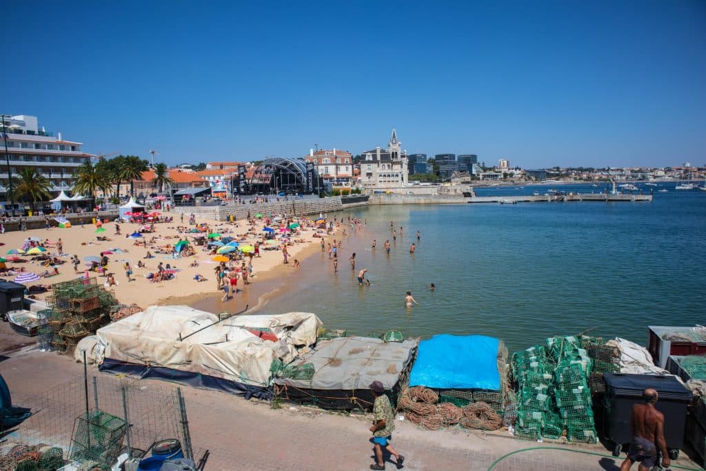 ludzie kapia sie w malej zatoczce blisko portu rybackiego w cascais 