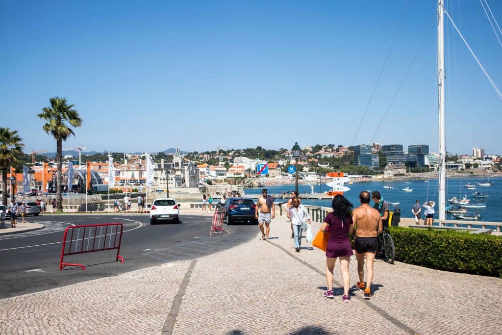 people walking on a busy street in cascais. 