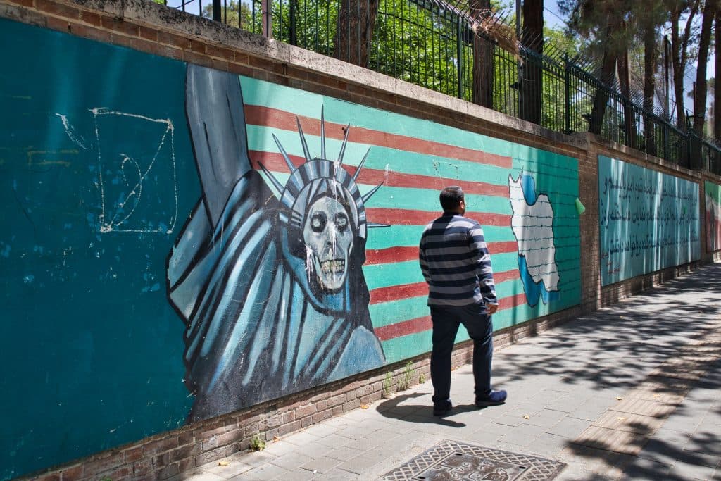 a man walks pass the former american embassy in teheran