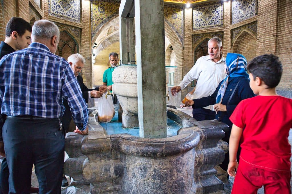 people standing at a well in grand bazaar in teheran 