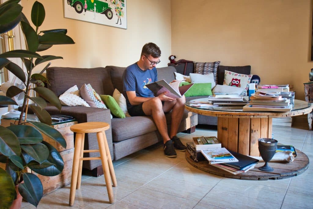 man sitting on a couch and reading a book at valencia mindfulness retreat