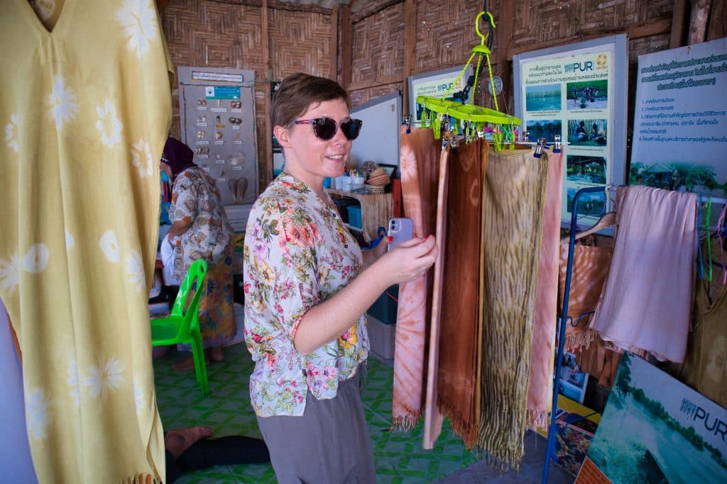 a foreign woman looks at colourful scarves in a thai village in koh klang, krabi, thailand.  