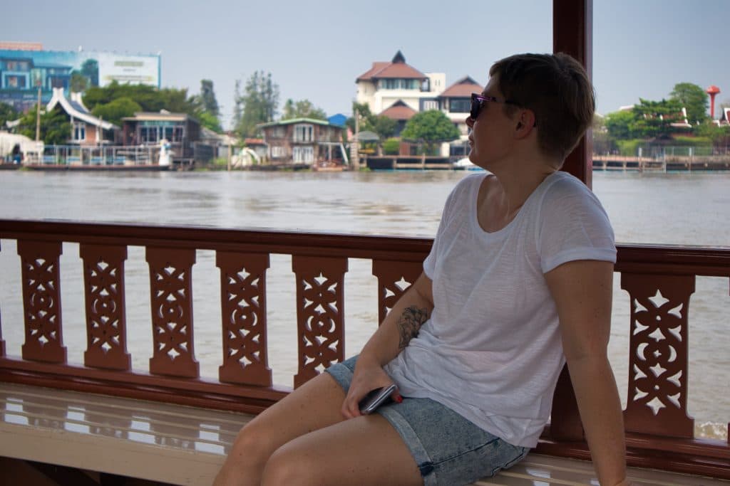 a woman sits on a boat going to koh kret in bangkok 