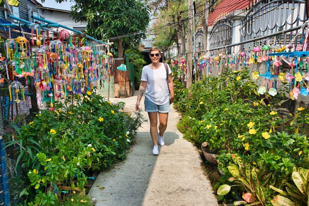a woman walking on a colourful street on koh kret in bangkok. 