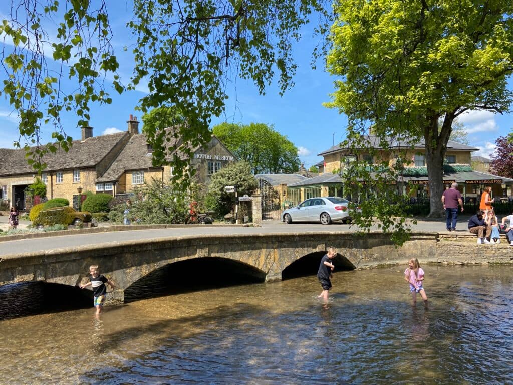 Dzieci bawią się w wodzie w miasteczku w Cotswolds.