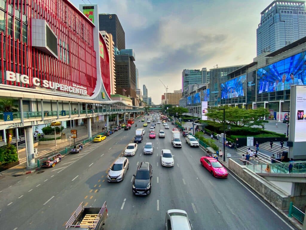 Traffic in Bangkok with modern shopping malls at the side of the street. 
