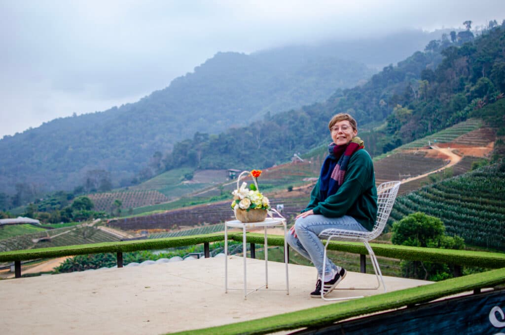 Dziewczyna siedzi na krześle z widokiem na góry w Chiang Mai. 