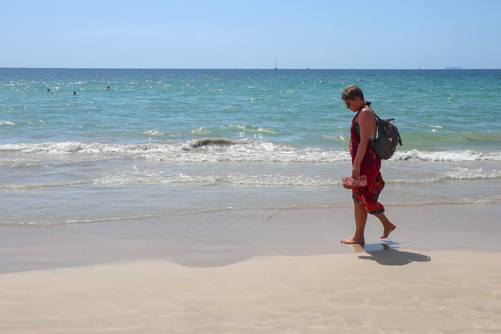 A woman walking along the beach on koh lanta. 