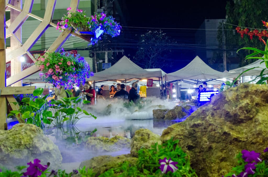 A fragment of the walking street in Chiang Rai, white tents and a mill. 