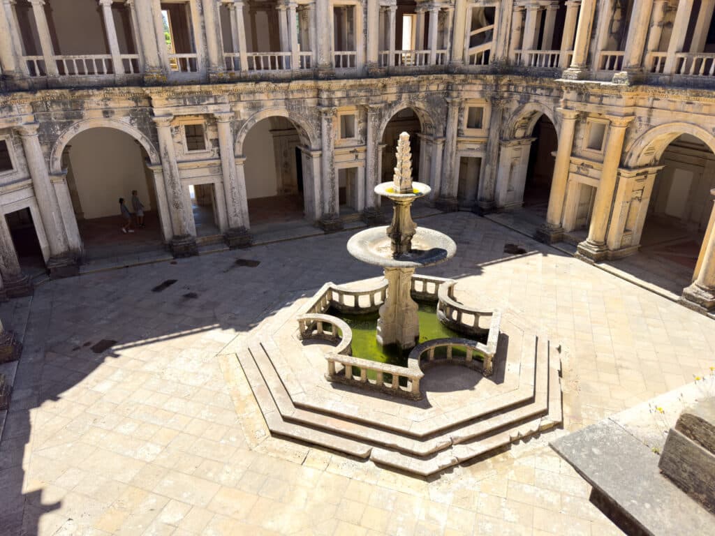 A fountain in the middle of a square, surrounded by an old building in Tomar, Portugal. 