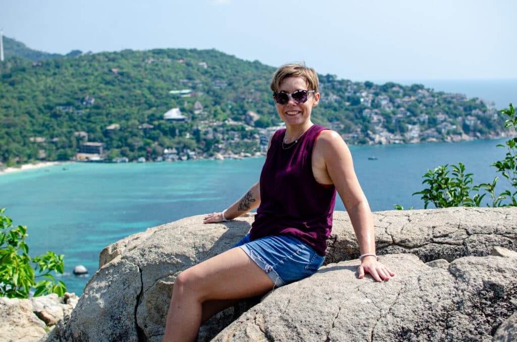 A woman sitting on a rock. 