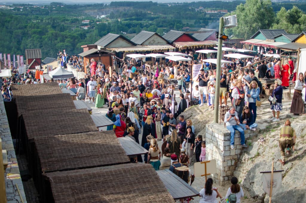 Tłumy ludzi przy straganach w obidos. 