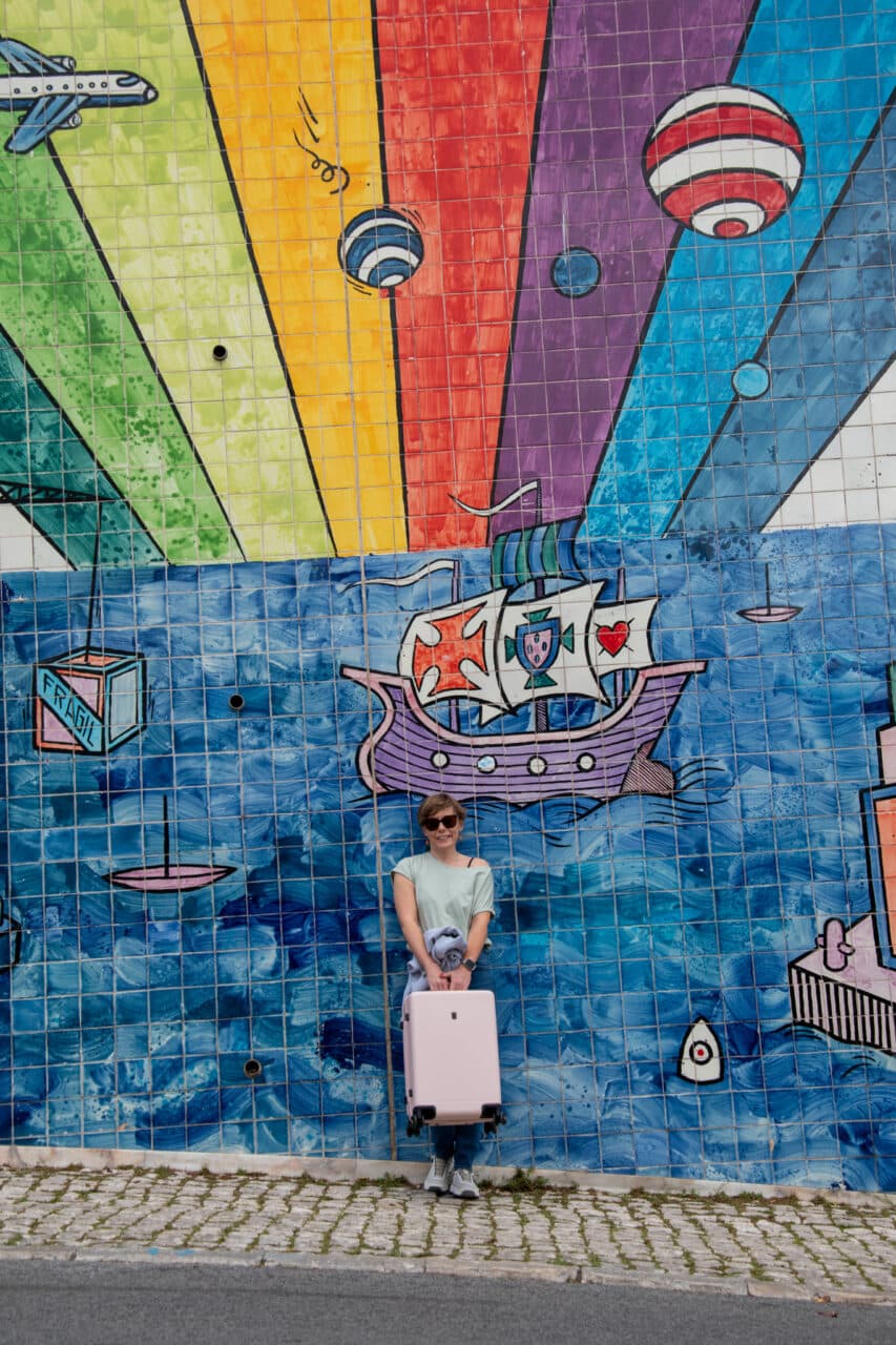 Lisbon, mural, walking with a suitcase