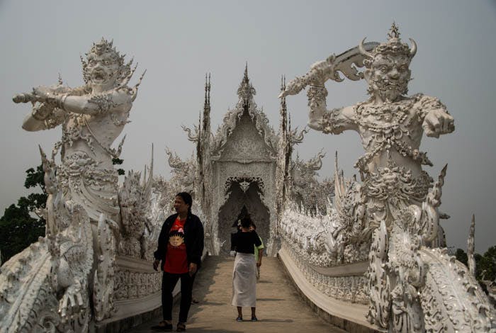 two demons guarding the bridge at the white temple in chiang rai
