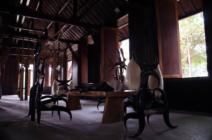 a table and chairs made out of bones and animal skin at the black house, chiang rai