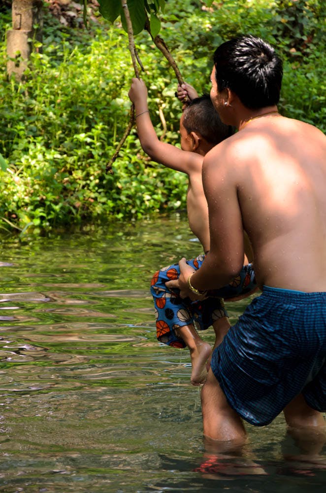 a child with his dad playing in a pool, in mean hong song, thailand