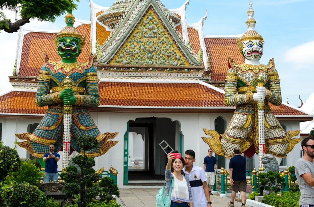 Giant statues in front of a gate at Wat Arun in Bangkok