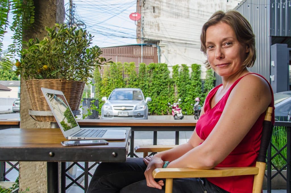 A woman sitting at the laptop in a cafe in chiang mai.