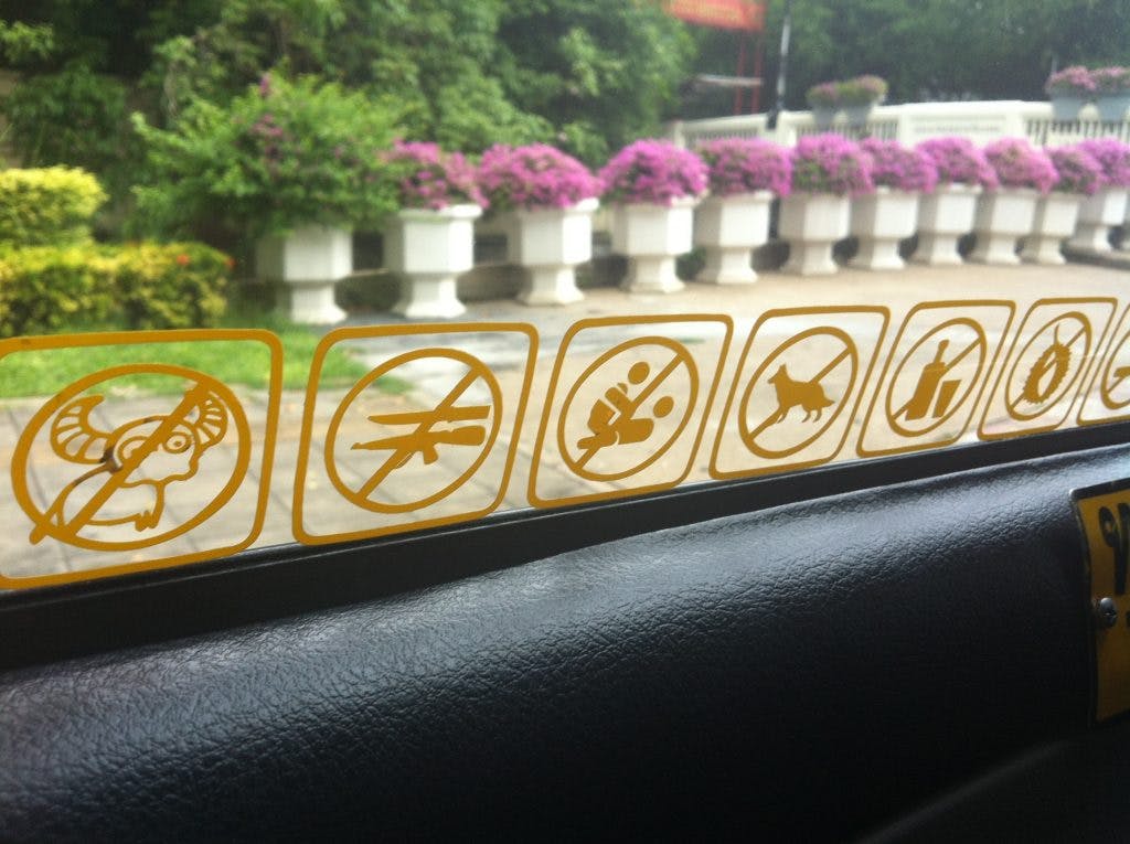stickers in a taxi in thailand showing no guns, no sex, no goats