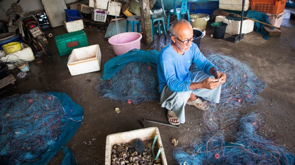 fisherman in rayong cleaning nets 