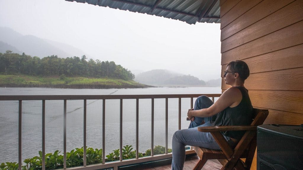 joanna horanin sits on a terrace by a lake and watches the rain