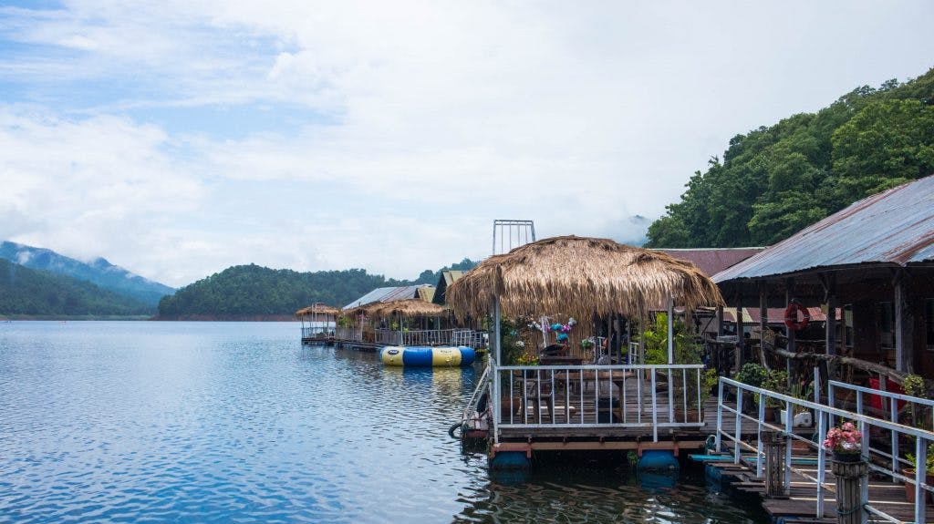 floating bungalows on mae ngat dam in thailand, bamboo terraces seen from the water