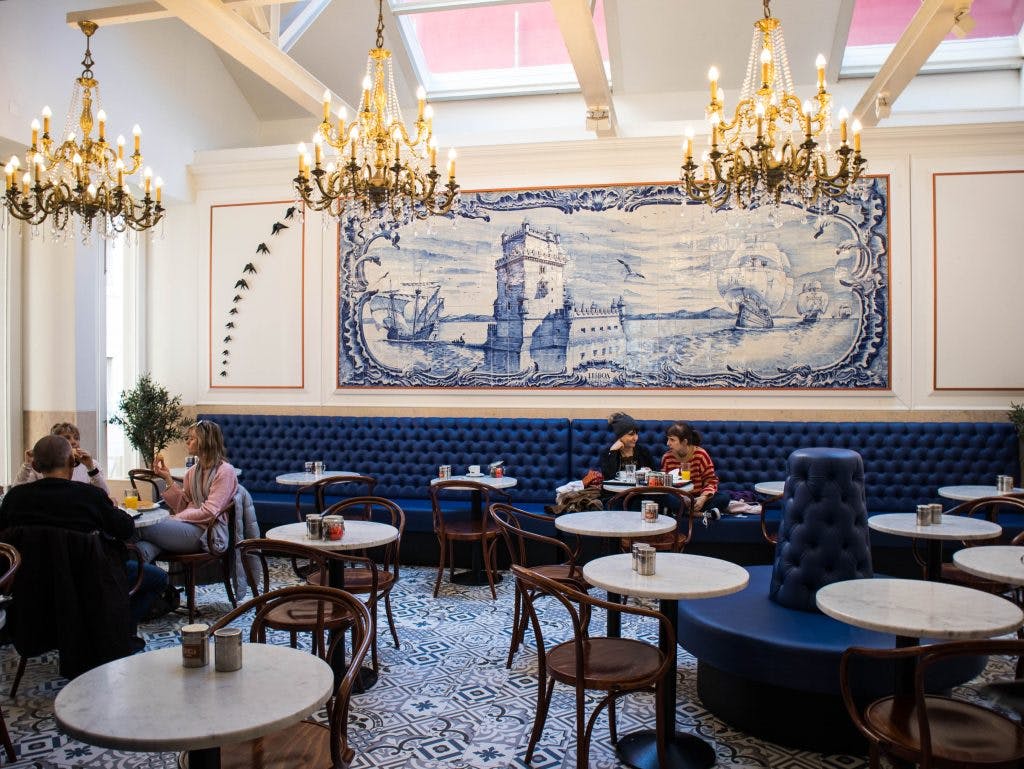 the interior of a coffee shop in lisbon with crystal chandeliers and tiles