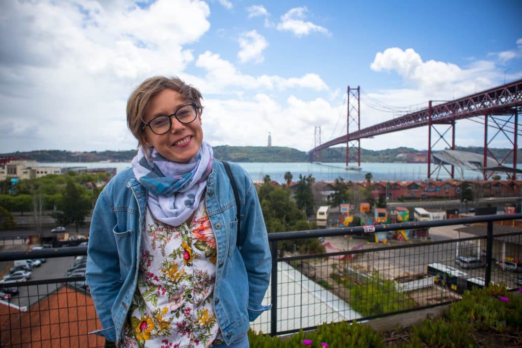 a girl stands at a bridge in lisbon in lx factory