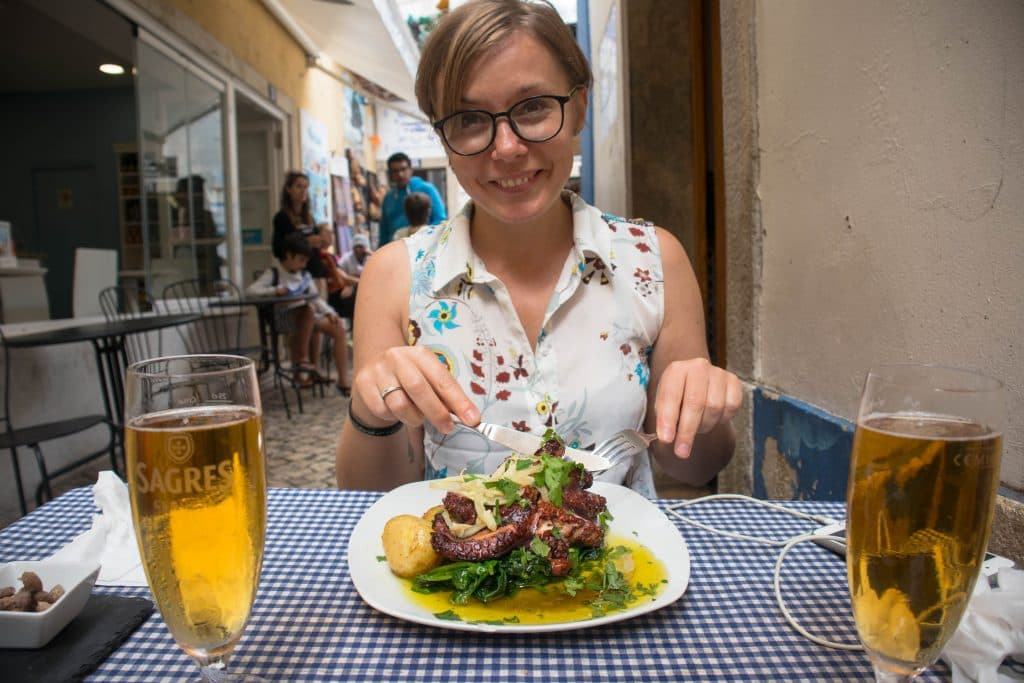 a girl eating octopus in lisbon