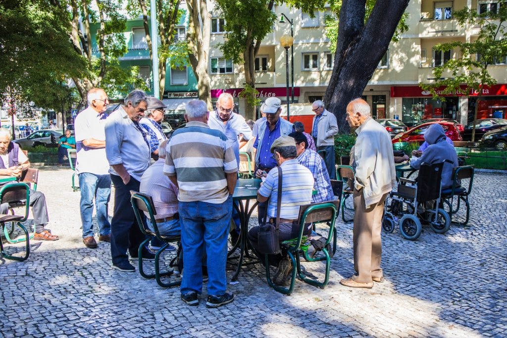starsi mezczyzni graja w karty w parku w lizbonie 