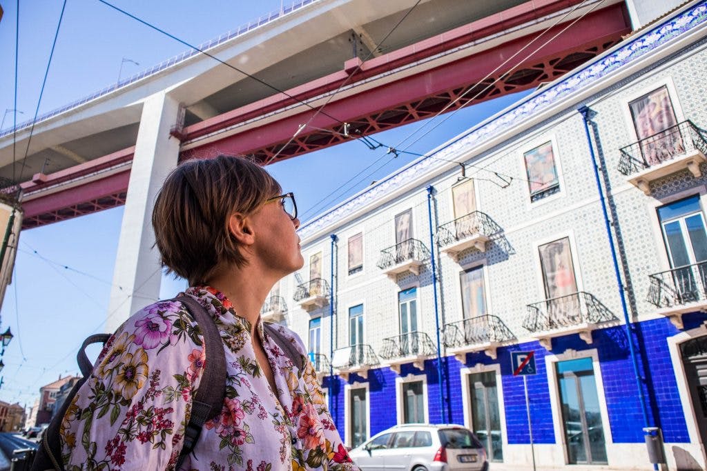 a girl looking at a colourful building in lisbon 