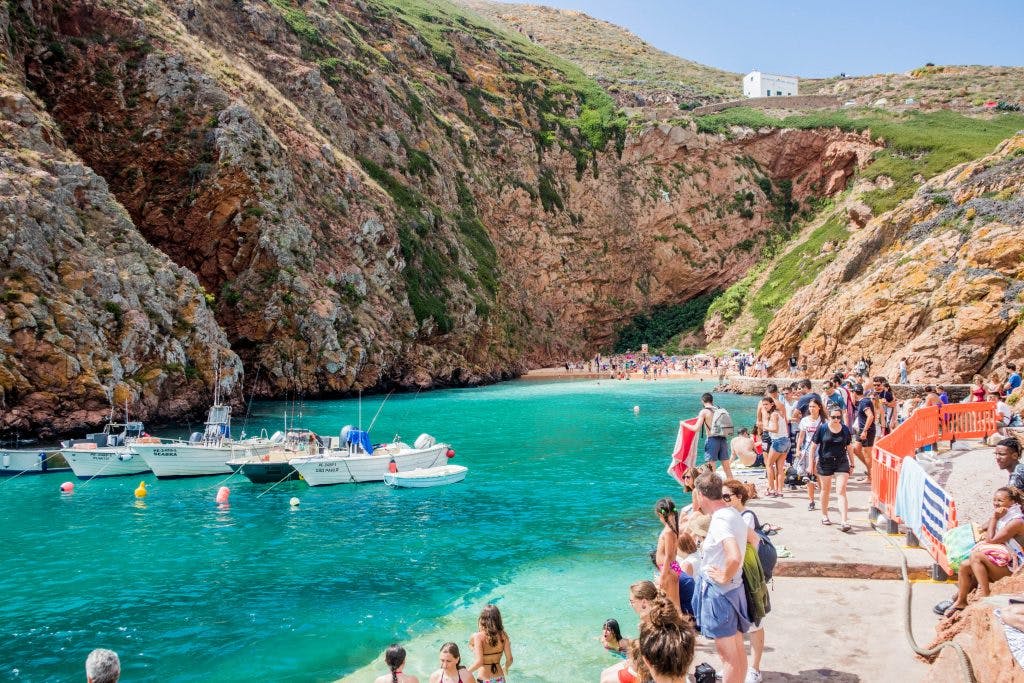 blue water at berlenga islands with tourists standing around 