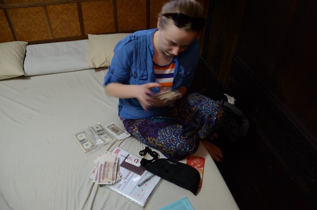 a girl is sitting on a matress counting money