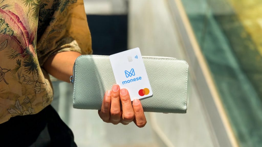 kobieta trzyma kartę monese i portfel 