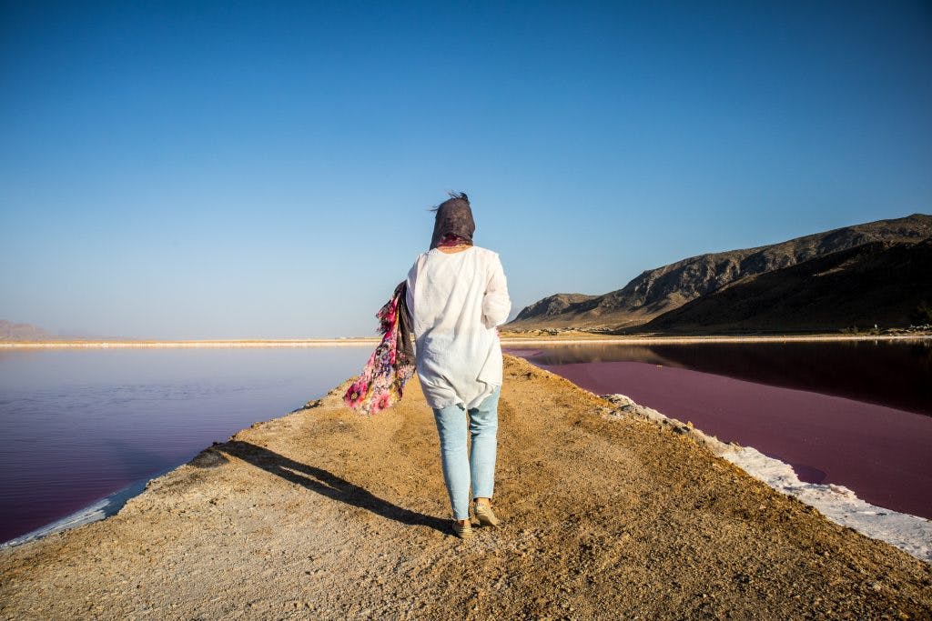 a girl walks on the maharloo lake in shiraz, iran