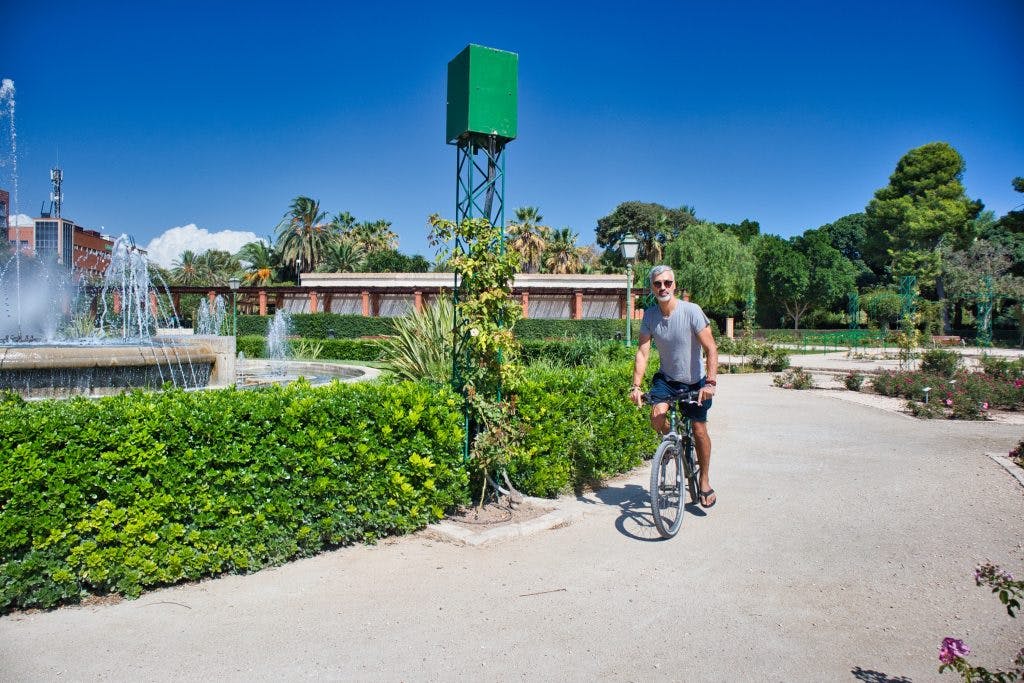 a man cycles in a park near a fountain in valencia spain