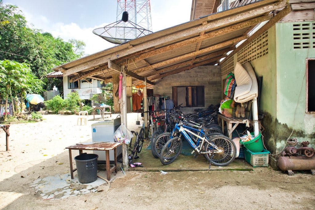 a yard in a thai village. bicycles under a roof